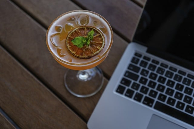 Do You Know the Rules of Remote Work? Take This Quiz open laptop with a cocktail next to it